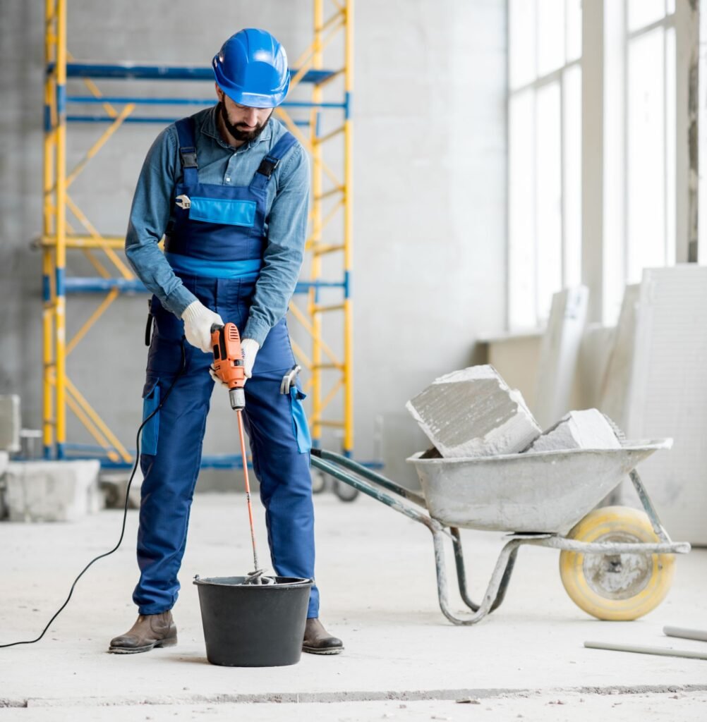 Muncitor amesteca compozitia in zona de constructie